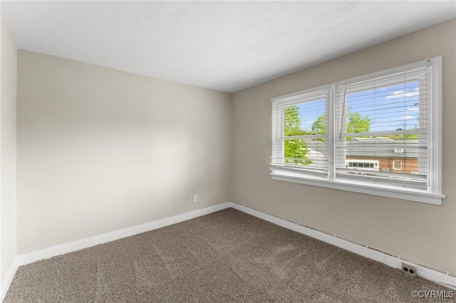 unfurnished room featuring baseboards and carpet