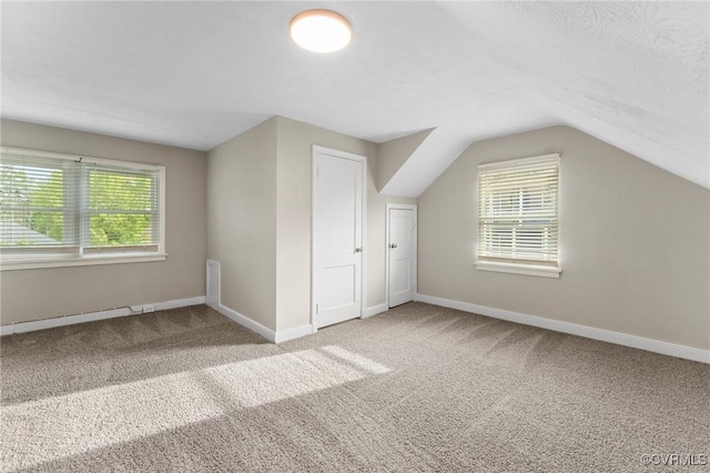 bonus room with carpet floors, a healthy amount of sunlight, vaulted ceiling, and baseboards