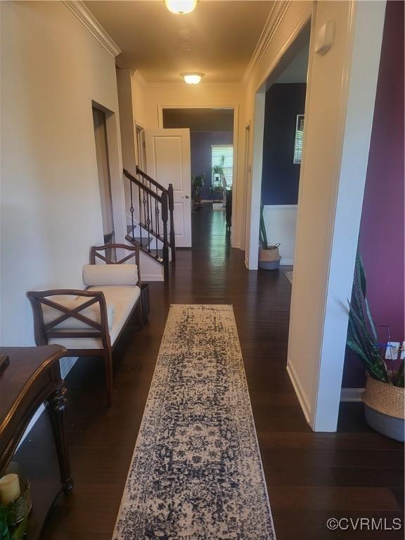 hallway featuring stairs, ornamental molding, and dark wood-style floors