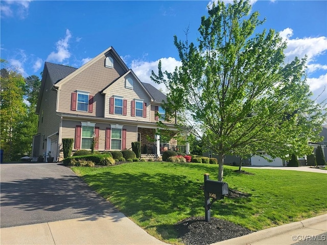 view of front facade with aphalt driveway, an attached garage, and a front lawn
