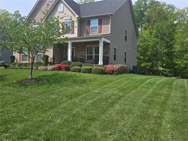 craftsman house with stone siding, covered porch, a front yard, and cooling unit