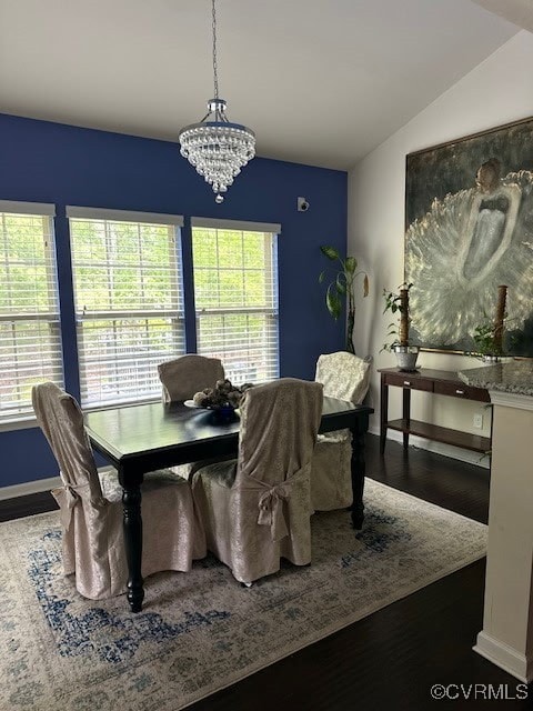 dining room featuring vaulted ceiling, an inviting chandelier, baseboards, and wood finished floors