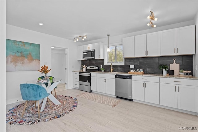 6512 River Rd, South Chesterfield, VA 23803 - kitchen with backsplash, appliances with stainless steel finishes, light wood finished floors, and white cabinets