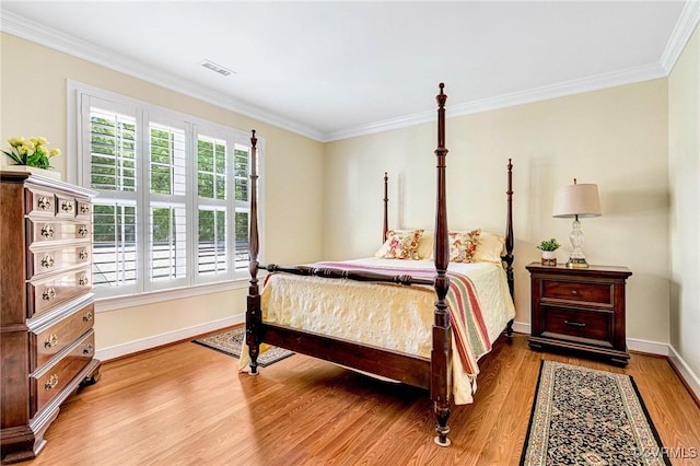 bedroom with baseboards, ornamental molding, wood finished floors, and visible vents
