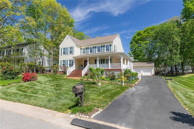 colonial inspired home with a porch, a garage, an outbuilding, and a front yard