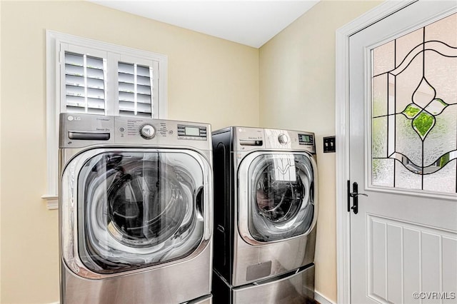 laundry area featuring baseboards, laundry area, washing machine and dryer, and a wealth of natural light