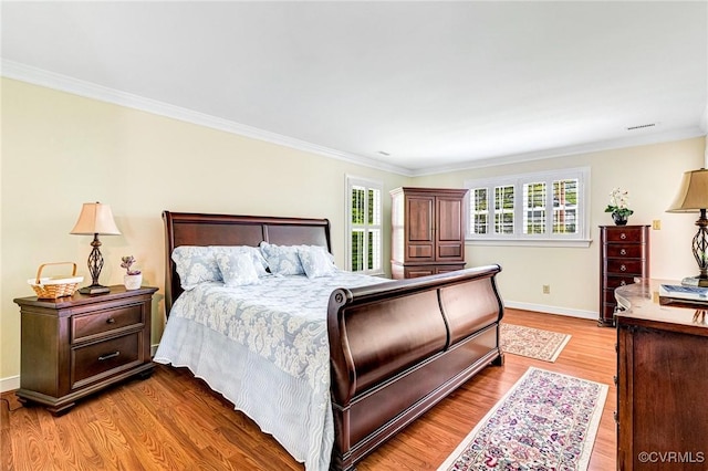 bedroom with baseboards, crown molding, and wood finished floors