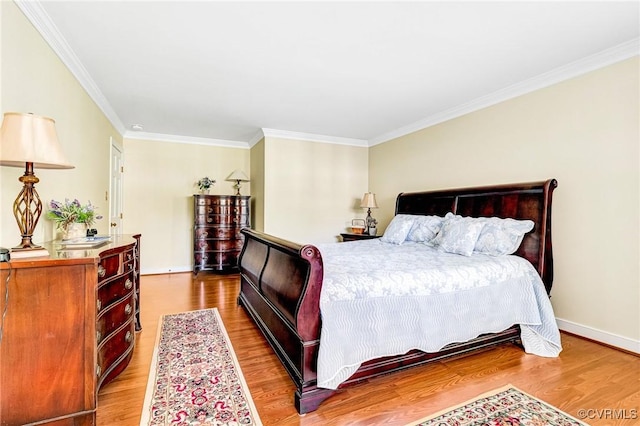 bedroom with crown molding, baseboards, and wood finished floors