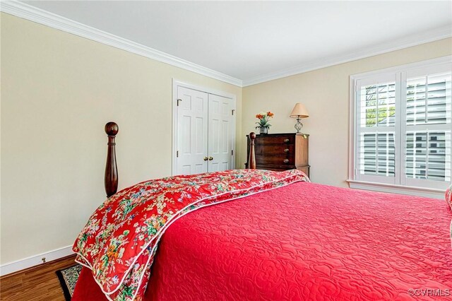 bedroom with baseboards, ornamental molding, a closet, and wood finished floors