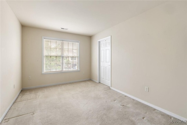 carpeted empty room with baseboards and visible vents