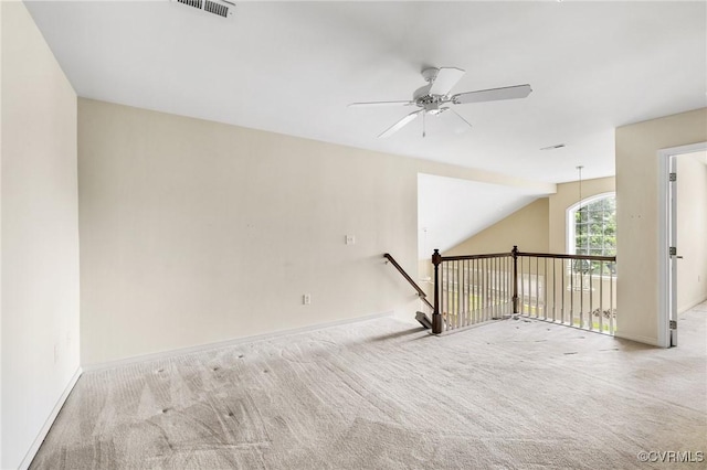carpeted empty room featuring baseboards, visible vents, and ceiling fan