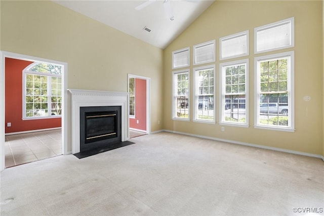 unfurnished living room featuring carpet flooring, high vaulted ceiling, a fireplace with flush hearth, visible vents, and ceiling fan