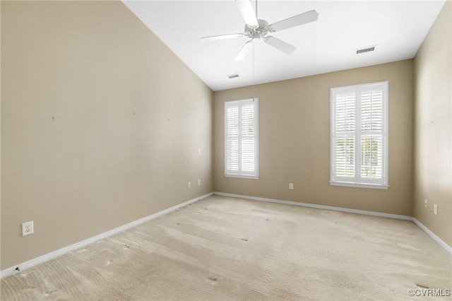 spare room with baseboards, ceiling fan, light carpet, and visible vents