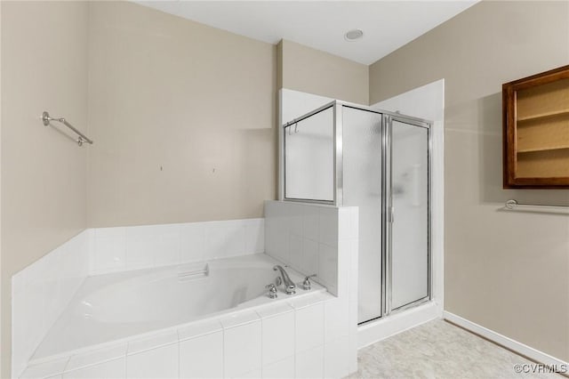 bathroom with a bath, baseboards, and a stall shower