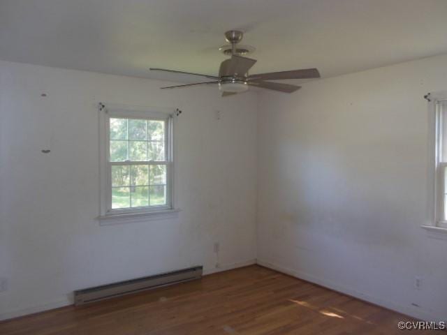 spare room featuring a baseboard radiator, wood finished floors, and a ceiling fan