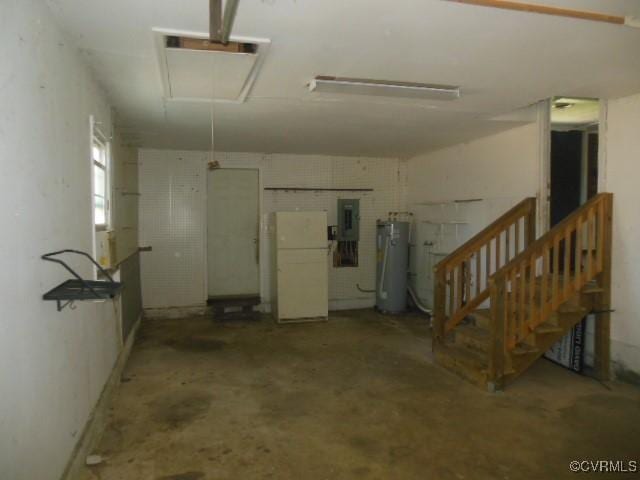 garage featuring freestanding refrigerator, electric panel, and water heater