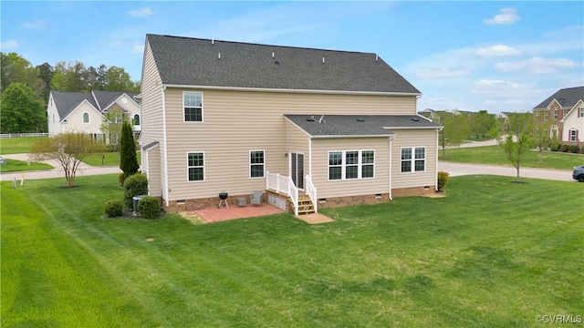 rear view of house featuring crawl space, a lawn, a patio area, and roof with shingles