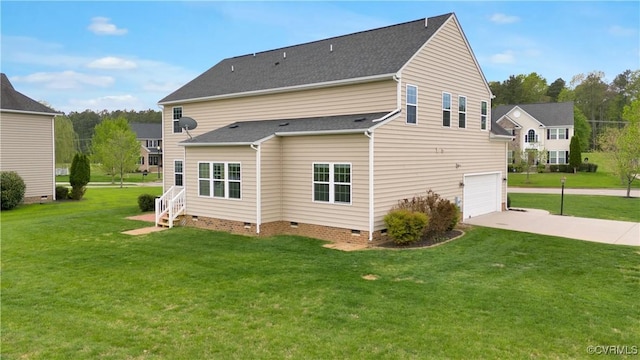 rear view of property with crawl space, an attached garage, driveway, and a yard