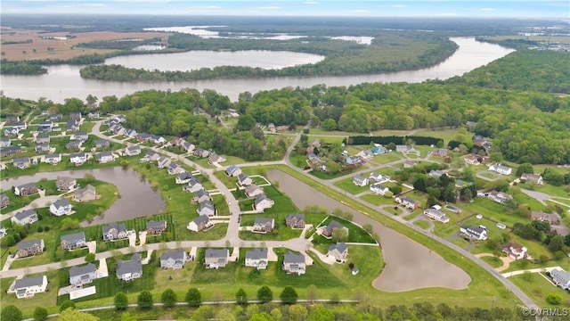 aerial view of property and surrounding area featuring a nearby body of water and nearby suburban area