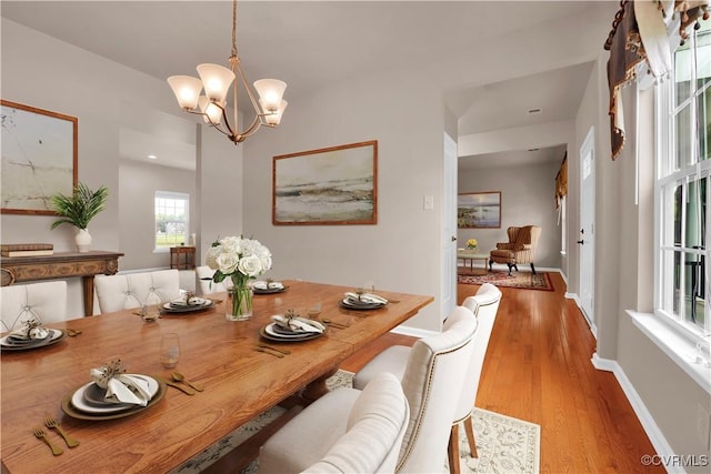 dining room with a chandelier, wood finished floors, and baseboards
