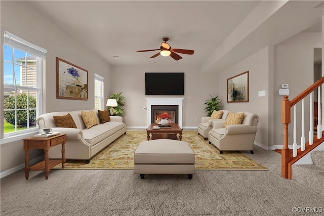 living area featuring ceiling fan, carpet, healthy amount of natural light, and baseboards