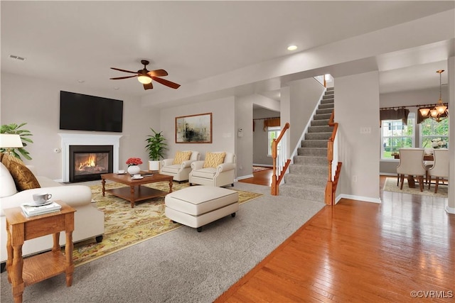 living area with hardwood / wood-style flooring, stairs, a fireplace with flush hearth, recessed lighting, and ceiling fan