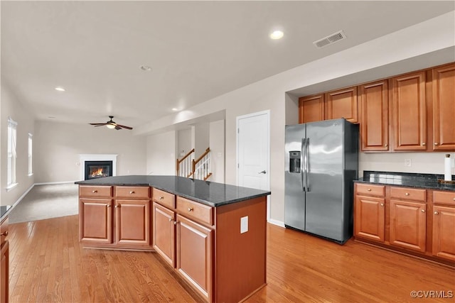 kitchen featuring stainless steel fridge, light wood finished floors, a ceiling fan, a kitchen island, and recessed lighting