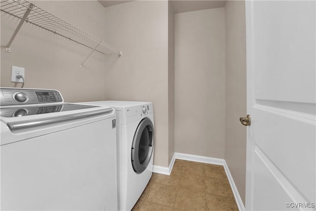 washroom with washer and dryer, baseboards, and light tile patterned flooring