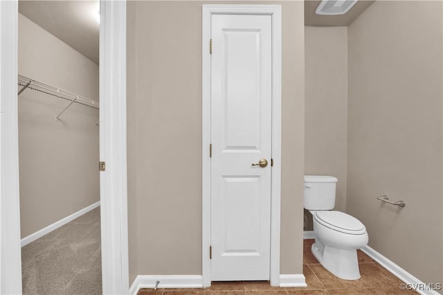 bathroom with toilet and baseboards
