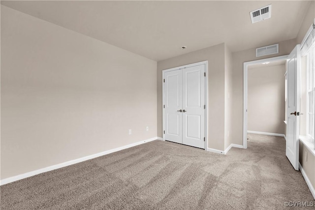 unfurnished bedroom with carpet flooring, baseboards, and a closet