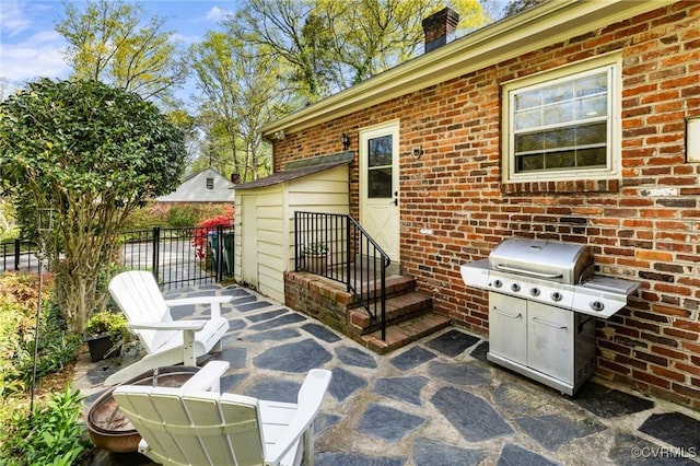 view of patio with fence and a grill