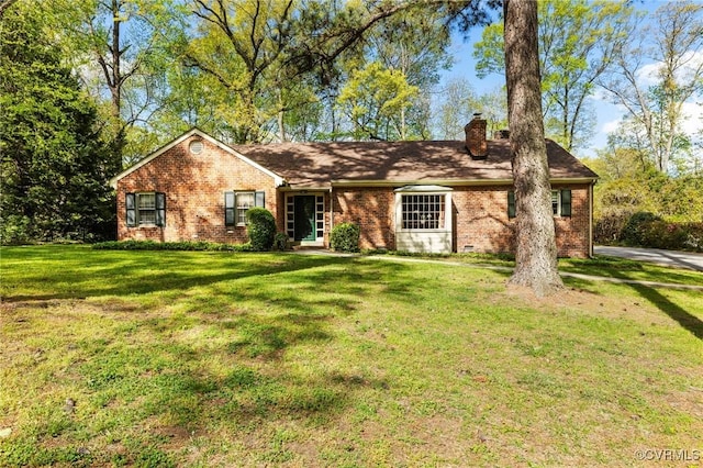 single story home featuring brick siding, a front lawn, and a chimney
