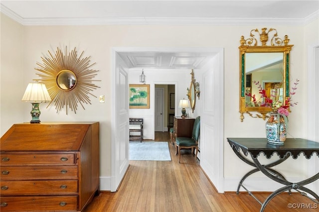 hall with baseboards, attic access, wood finished floors, and ornamental molding