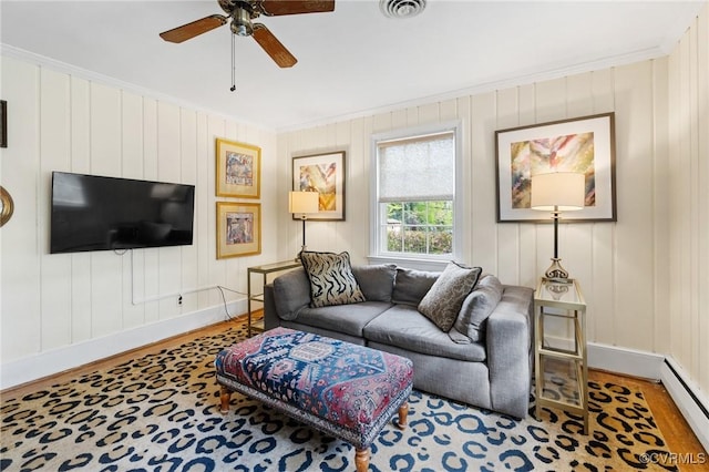 living area with a ceiling fan, visible vents, crown molding, wood finished floors, and a baseboard radiator