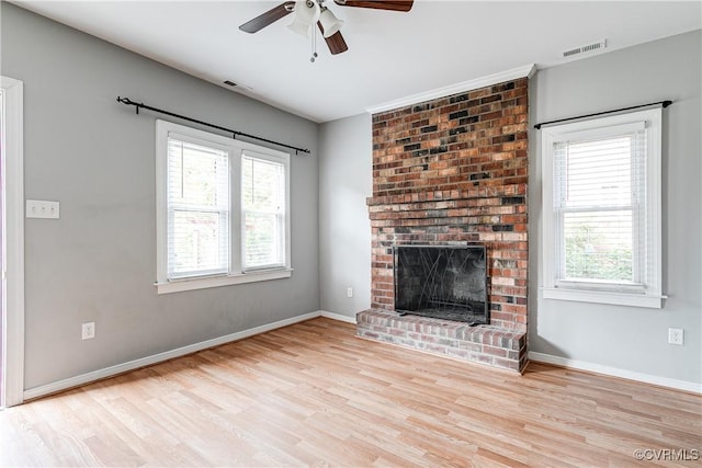 unfurnished living room featuring visible vents, ceiling fan, wood finished floors, and a wealth of natural light