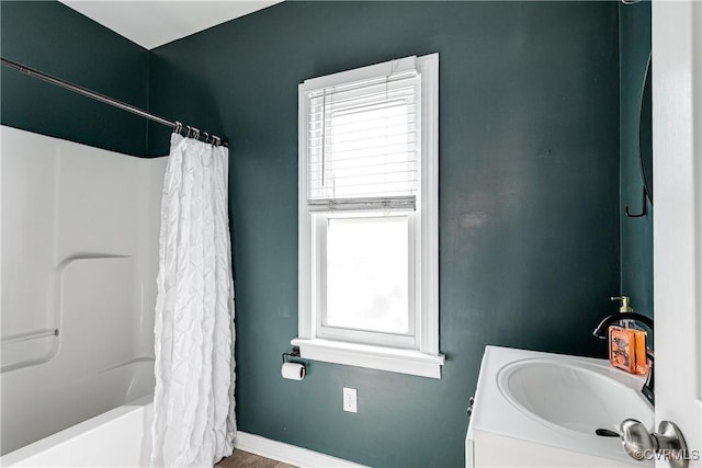 full bathroom featuring a healthy amount of sunlight, baseboards, vanity, and wood finished floors
