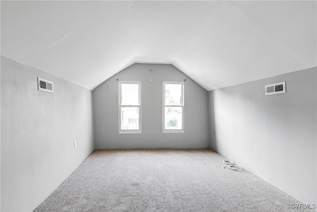 additional living space featuring visible vents, carpet, and vaulted ceiling