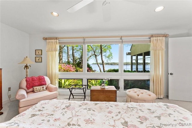 carpeted bedroom with baseboards, recessed lighting, multiple windows, and a water view