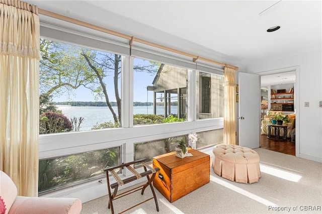 sunroom featuring a water view