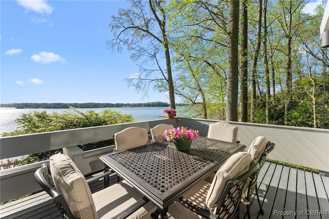 wooden deck featuring outdoor dining space and a water view