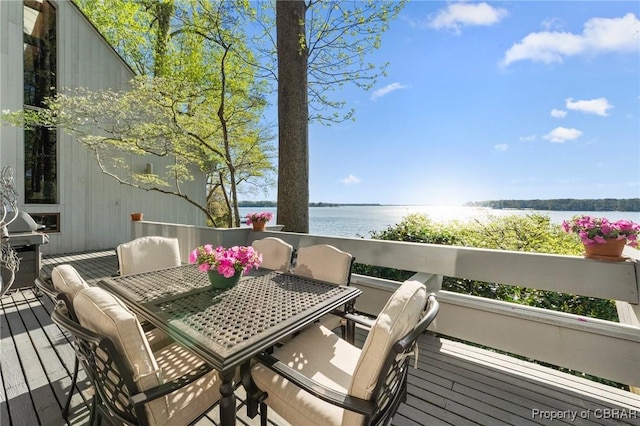 wooden deck featuring outdoor dining space and a water view