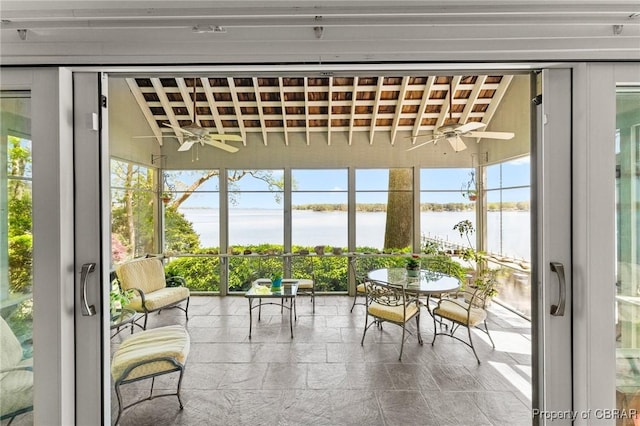 sunroom / solarium featuring plenty of natural light, a water view, and ceiling fan