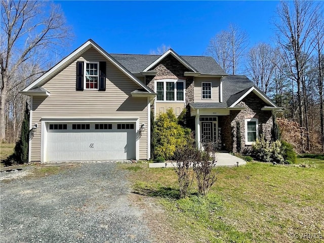 craftsman-style home with a garage, driveway, stone siding, and a front yard