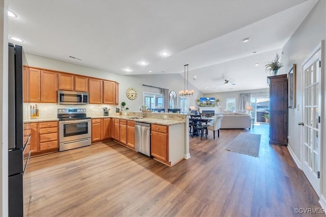 kitchen featuring appliances with stainless steel finishes, vaulted ceiling, open floor plan, and a wealth of natural light