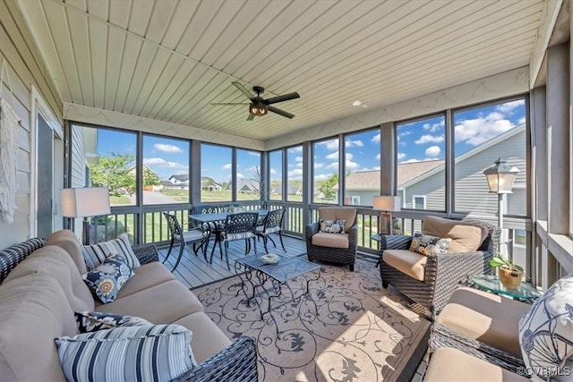 sunroom featuring an outdoor hangout area, ceiling fan, and a residential view