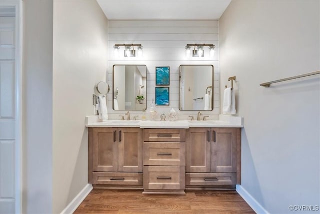 bathroom with baseboards, a sink, and wood finished floors