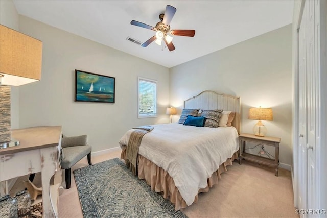 bedroom with light colored carpet, baseboards, visible vents, and ceiling fan