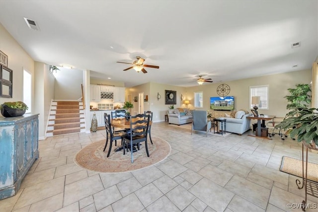 dining room featuring visible vents, a ceiling fan, baseboards, and stairway