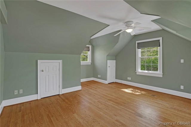 bonus room featuring vaulted ceiling, baseboards, a ceiling fan, and wood finished floors