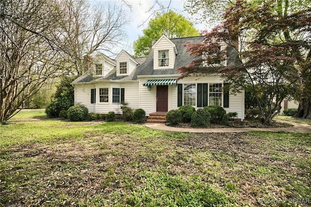cape cod house with a shingled roof and a front lawn